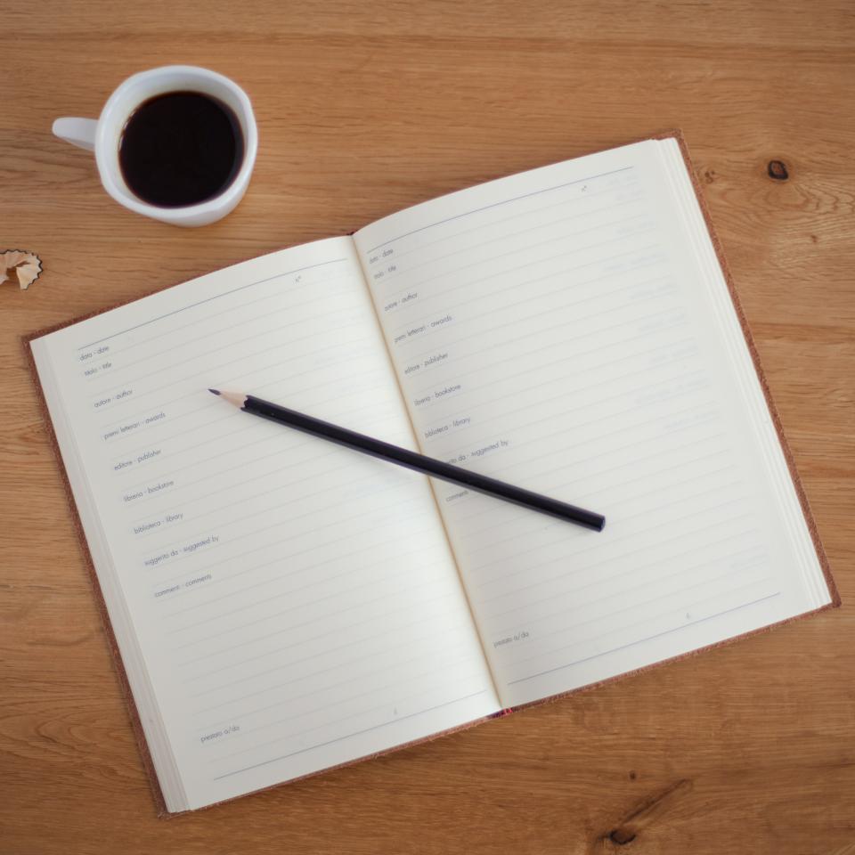 An open planning book, pencil, and coffee